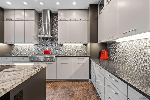 kitchen with backsplash, dark stone counters, and wall chimney exhaust hood