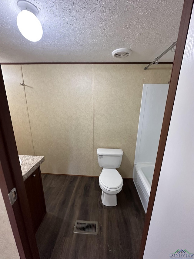 12700 2184 D, Tatum, TX 75691 - bathroom with wood finished floors, toilet, a textured ceiling, and vanity