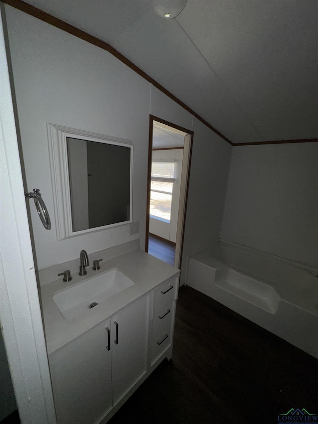 12700 2184 D, Tatum, TX 75691 - bathroom with lofted ceiling, vanity, a bathtub, and wood finished floors