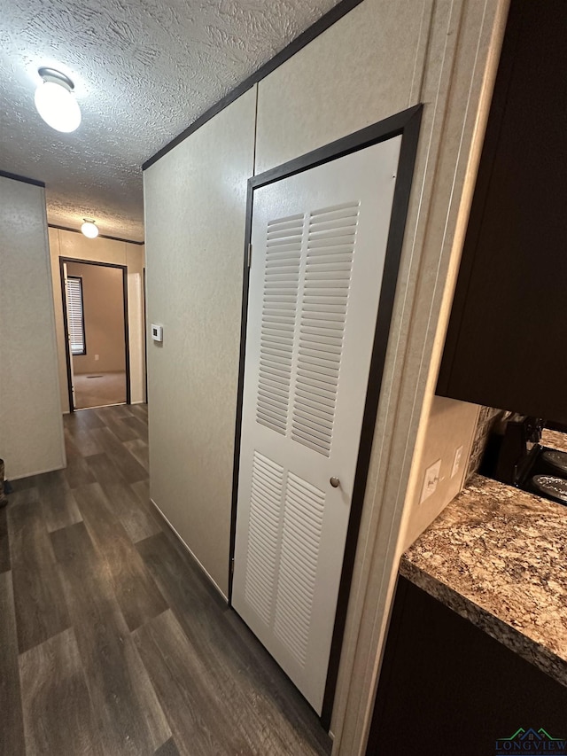 12700 2184 D, Tatum, TX 75691 - hallway featuring dark wood finished floors and a textured ceiling