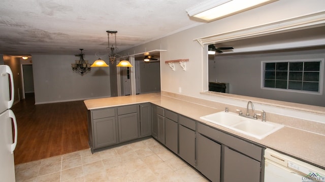 kitchen featuring white appliances, sink, gray cabinets, decorative light fixtures, and kitchen peninsula