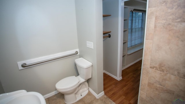 bathroom with built in features, wood-type flooring, and toilet