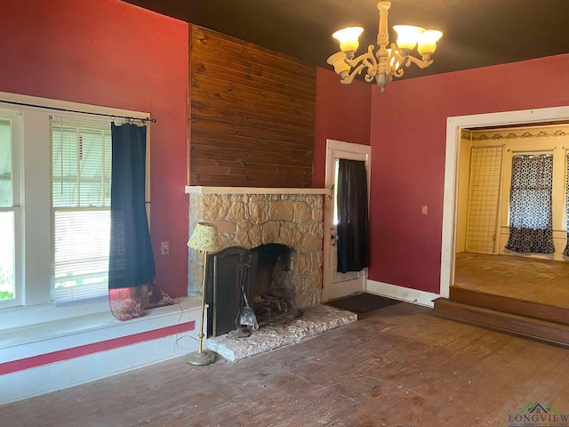 unfurnished living room with a fireplace, dark hardwood / wood-style flooring, and a notable chandelier