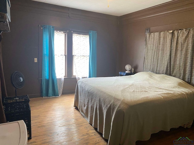 bedroom with light hardwood / wood-style floors and ornamental molding