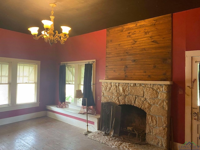 unfurnished living room featuring hardwood / wood-style floors, a notable chandelier, and a fireplace