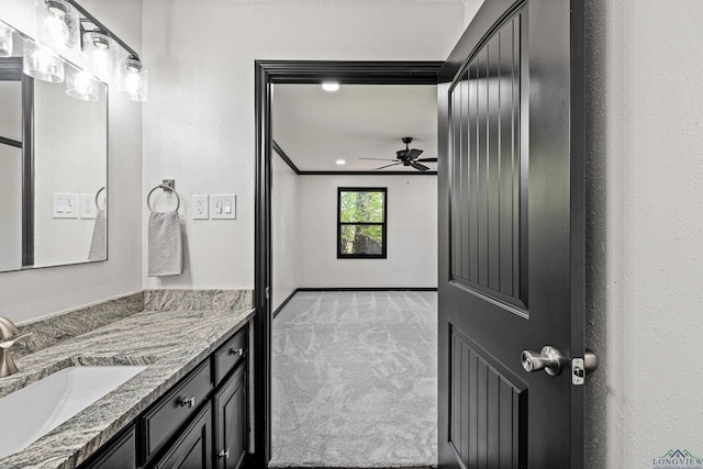 bathroom featuring ceiling fan, vanity, and ornamental molding