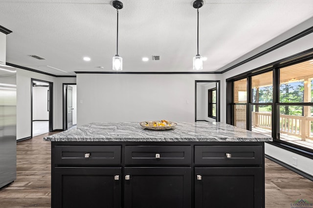 kitchen featuring dark hardwood / wood-style flooring, a kitchen island, and pendant lighting