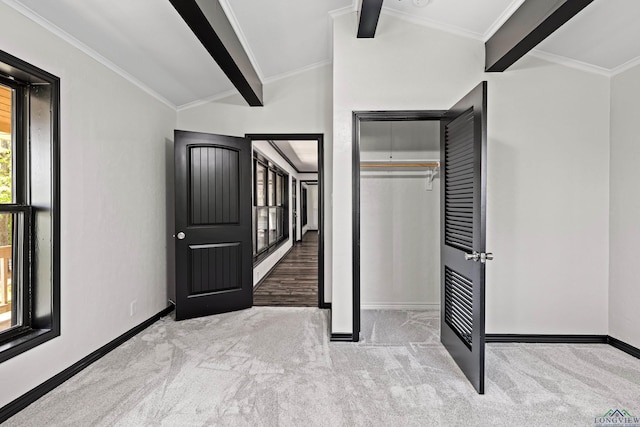 unfurnished bedroom with light carpet, a closet, beamed ceiling, and crown molding