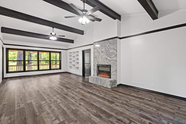 unfurnished living room featuring built in shelves, ceiling fan, lofted ceiling with beams, a fireplace, and dark hardwood / wood-style floors