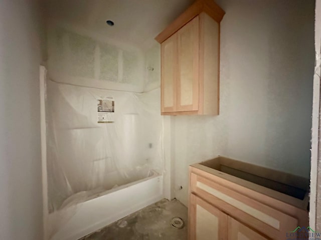 bathroom with vanity, shower / washtub combination, and concrete floors