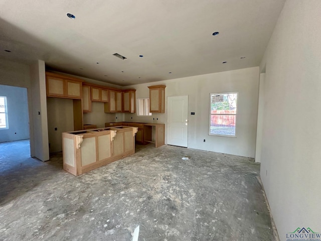 kitchen with a kitchen island, light brown cabinetry, and a wealth of natural light