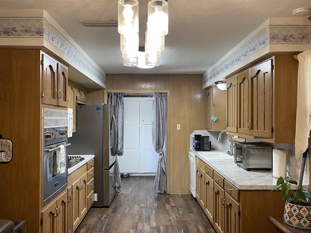 411 E Carolanne Blvd, Marshall, TX 75672 - kitchen featuring a sink, appliances with stainless steel finishes, light countertops, dark wood-style floors, and brown cabinets