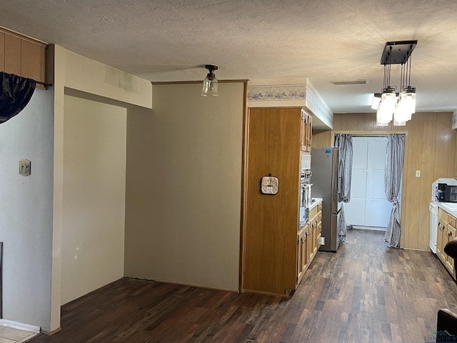 411 E Carolanne Blvd, Marshall, TX 75672 - kitchen featuring dark wood-style floors, brown cabinets, freestanding refrigerator, light countertops, and a textured ceiling