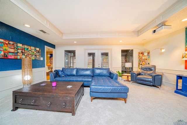 carpeted living room featuring french doors and a tray ceiling