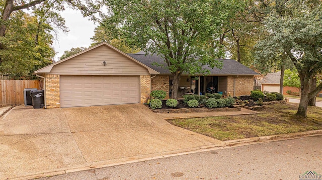 ranch-style house with a garage and central AC unit