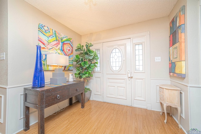 entrance foyer with light wood-type flooring and a textured ceiling