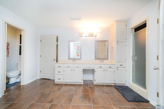 bathroom with tile patterned flooring, vanity, an enclosed shower, and toilet