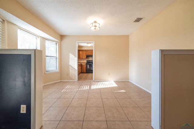 interior space with a textured ceiling and light tile patterned floors