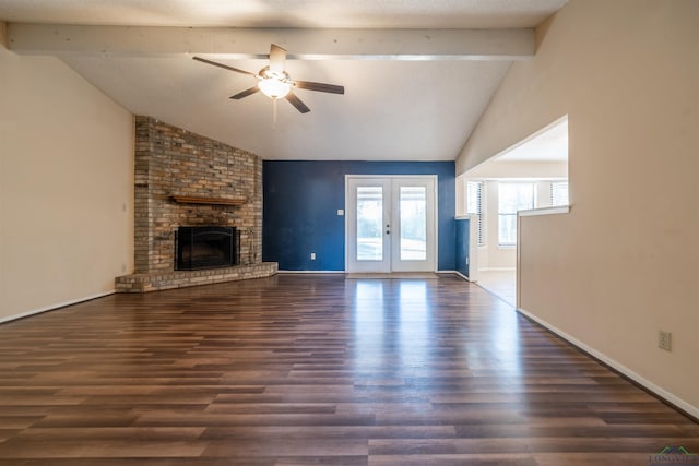 unfurnished living room featuring dark wood-type flooring, lofted ceiling with beams, french doors, a brick fireplace, and ceiling fan