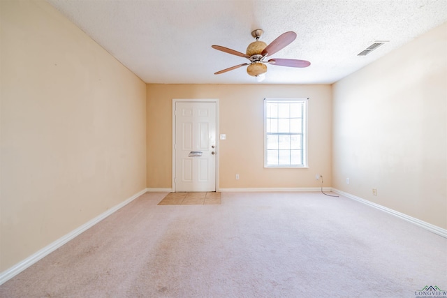 carpeted spare room with a textured ceiling and ceiling fan