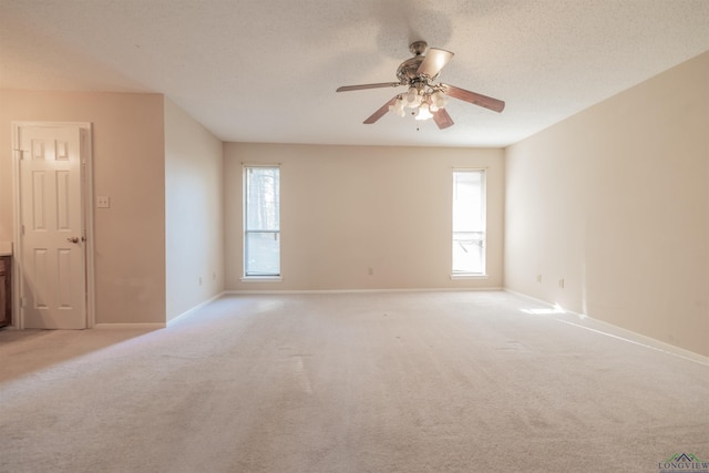 carpeted spare room featuring a textured ceiling and ceiling fan