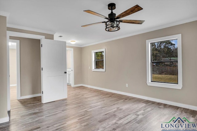 spare room with light wood-type flooring, ceiling fan, a healthy amount of sunlight, and crown molding