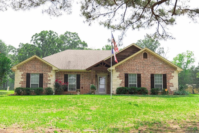 3713 Bell Mdws, Longview, TX 75605 - view of front of house with brick siding, a front yard, and a shingled roof
