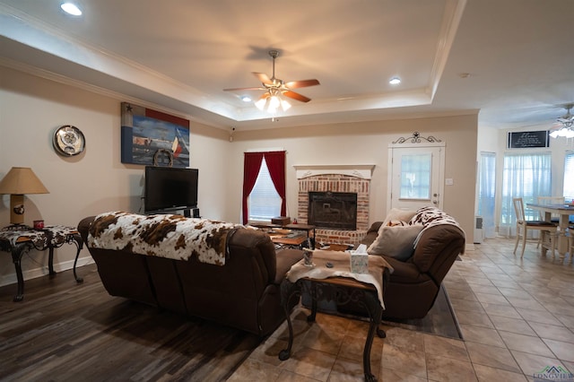 3713 Bell Mdws, Longview, TX 75605 - living area with a ceiling fan, a tray ceiling, ornamental molding, a fireplace, and plenty of natural light