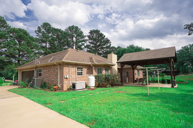 3713 Bell Mdws, Longview, TX 75605 - back of house featuring a gazebo, brick siding, central AC unit, a patio area, and a lawn