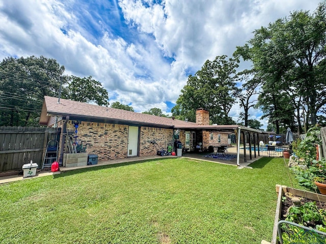 902 Warren Dr, Marshall, TX 75672 - rear view of house with a chimney, brick siding, and a patio