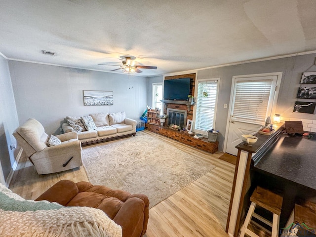 902 Warren Dr, Marshall, TX 75672 - living room with ornamental molding, light wood-style floors, a ceiling fan, and a fireplace