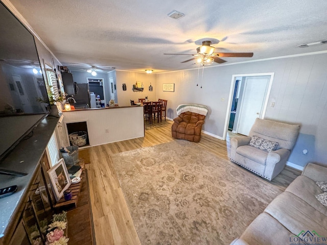902 Warren Dr, Marshall, TX 75672 - living room with ceiling fan, a textured ceiling, wood finished floors, and crown molding