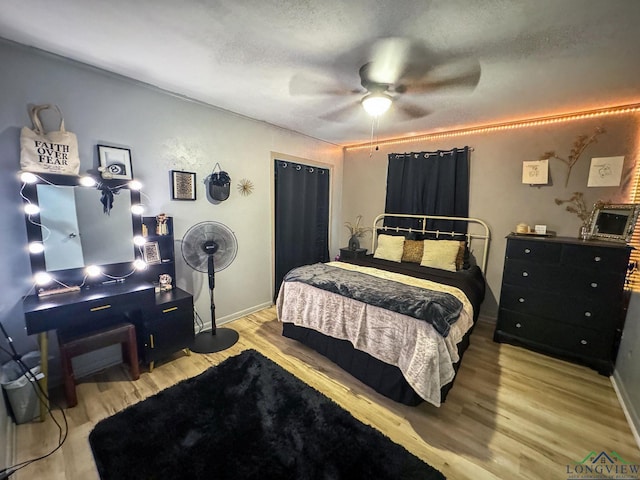 902 Warren Dr, Marshall, TX 75672 - bedroom featuring wood finished floors, ceiling fan, a closet, and a textured ceiling