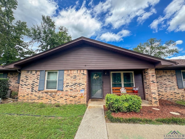 902 Warren Dr, Marshall, TX 75672 - view of front facade featuring brick siding and a front lawn