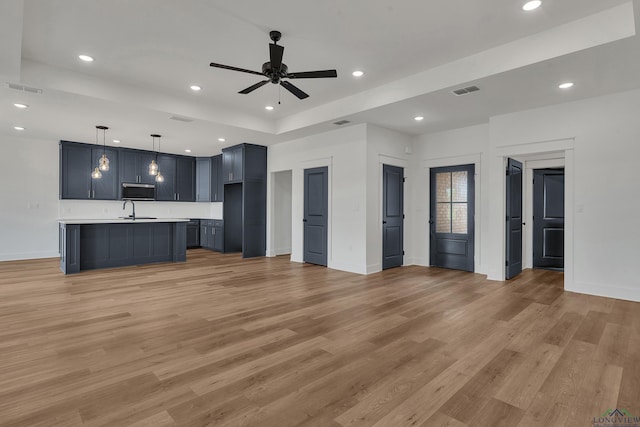 1507 Wellington Ln, Longview, TX 75605 - unfurnished living room featuring recessed lighting, light wood-style flooring, baseboards, a ceiling fan, and a sink