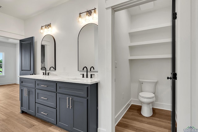 1507 Wellington Ln, Longview, TX 75605 - full bath with double vanity, wood finished floors, toilet, and baseboards