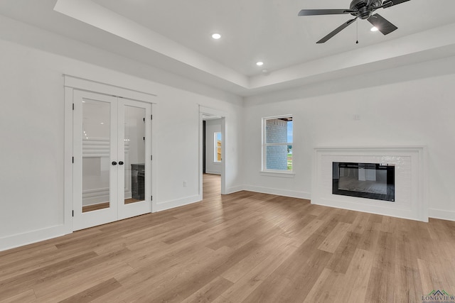 1507 Wellington Ln, Longview, TX 75605 - unfurnished living room featuring french doors, light wood-style floors, a tray ceiling, recessed lighting, and baseboards