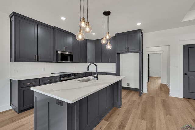1507 Wellington Ln, Longview, TX 75605 - kitchen with stainless steel microwave, a sink, black electric range, light stone counters, and light wood-style flooring