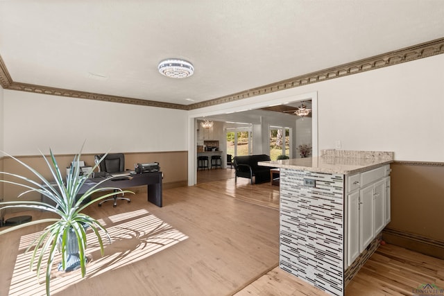 living room featuring light wood-type flooring, ceiling fan, and ornamental molding