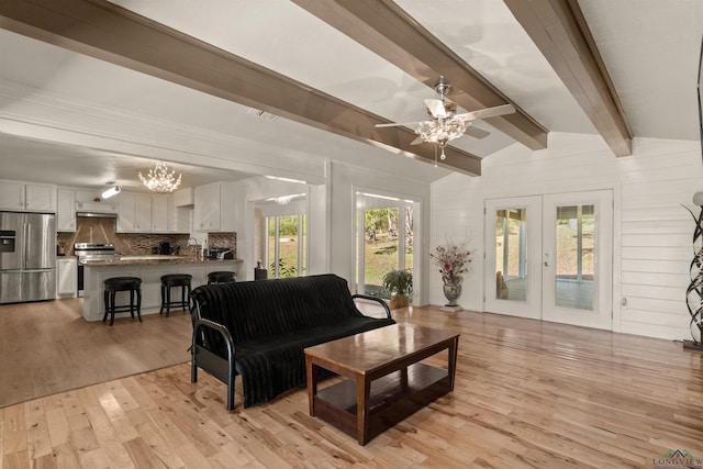 living room with vaulted ceiling with beams, french doors, ceiling fan with notable chandelier, and light wood-type flooring