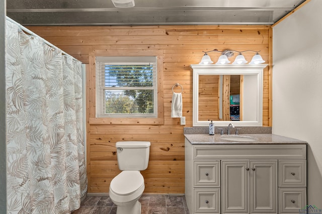 bathroom with vanity, wood walls, and toilet