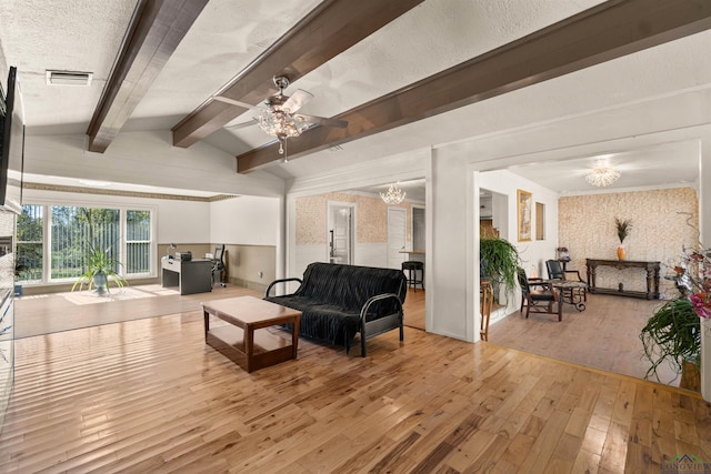 interior space with lofted ceiling with beams, wood-type flooring, a textured ceiling, and ceiling fan with notable chandelier