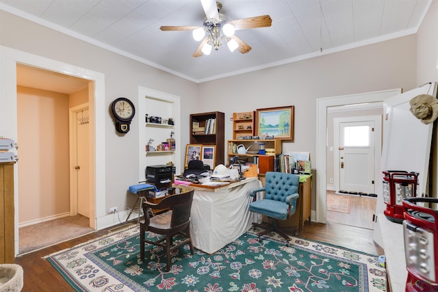 office area with built in shelves, ceiling fan, dark hardwood / wood-style flooring, and crown molding