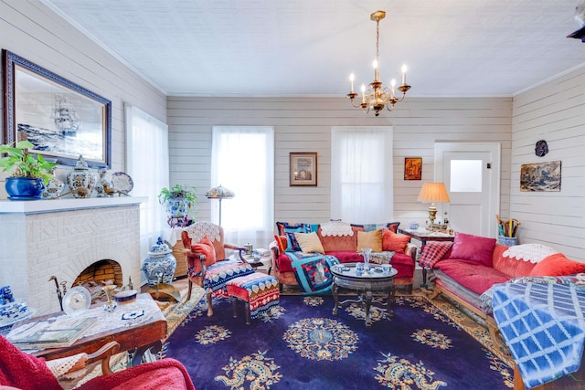 living room featuring a fireplace, an inviting chandelier, wooden walls, and crown molding