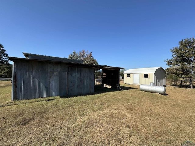 view of outdoor structure featuring a carport and a lawn