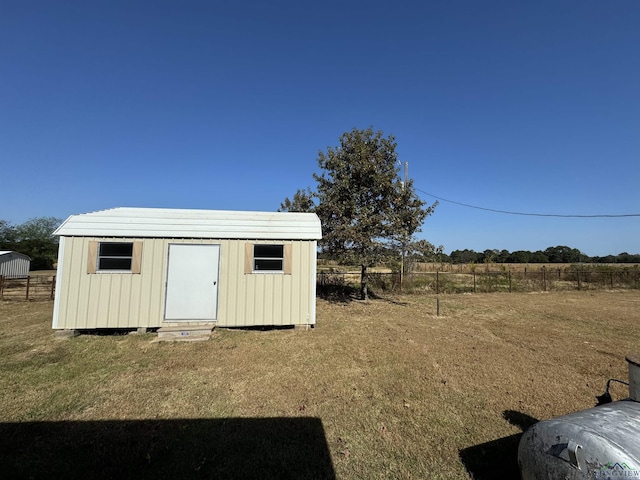 view of outdoor structure with a lawn and a rural view