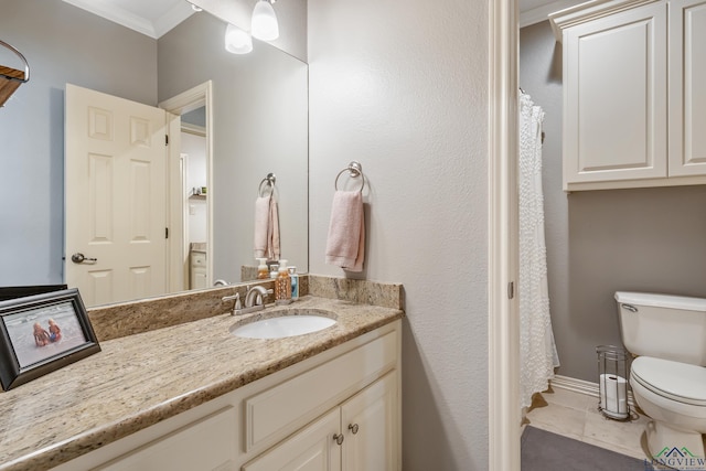 bathroom featuring baseboards, toilet, tile patterned floors, crown molding, and vanity