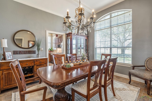 dining area featuring ornamental molding, baseboards, and an inviting chandelier