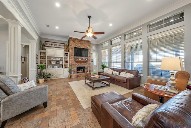 living area with decorative columns, visible vents, ornamental molding, and ceiling fan