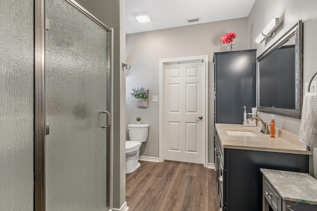 full bathroom featuring visible vents, toilet, a stall shower, vanity, and wood finished floors